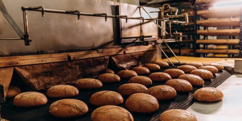 Automatic bakery production line with sweet cookies on conveyor belt equipment machinery in confectionary factory workshop, industrial food production Automated bakery production line streamlining operations and increasing efficiency